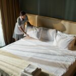 Housekeeper Making Bed in Hotel Room